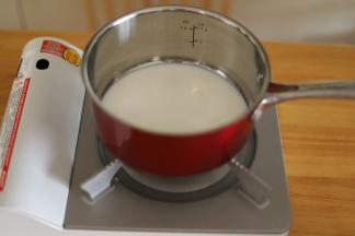100克的牛奶倒入奶锅内。