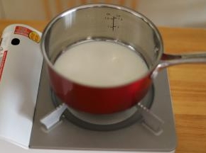 100克的牛奶倒入奶锅内。
