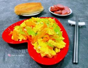 营养丰富的莴笋胡萝卜炒鸡蛋装入盘中搭配面包和香肠一起吃太棒了
