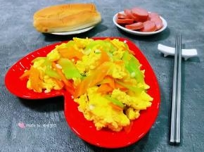 营养丰富的莴笋胡萝卜炒鸡蛋装入盘中搭配面包和香肠一起吃太棒了