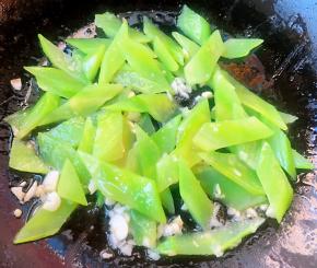 锅中倒入底油加热放入蒜粒爆香再放入莴笋片炒匀