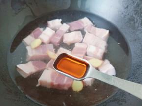 锅里放适量的清水，放入五花肉与料酒，生姜片。