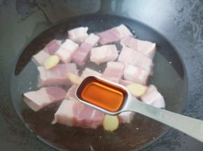 锅里放适量的清水，放入五花肉与料酒，生姜片。