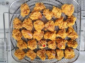 把裹好鸡蛋液和面包糠的鸡脆骨摆在空气炸烤籃里