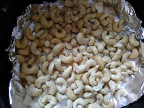 空气炸锅的炸篮先铺上一层锡纸，倒入腰果，铺平。180度先烤10分钟。