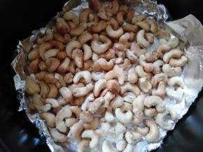 取出炸篮，将腰果翻一下面，尽量将白色的翻上来，已经烤黑的翻下去。再烤5分钟。