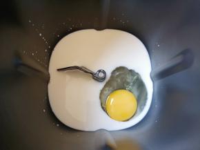 面包机桶内加入牛奶，打入一个鸡蛋。
