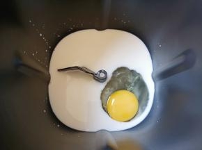面包机桶内加入牛奶，打入一个鸡蛋。