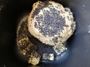 15分钟和面程序结束以后放入软化的黄油和熟黑芝麻，继续选择面包机的“自动和面”15分钟。