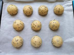 烤盘里铺上油纸，将面包面团滚圆放在油纸上。