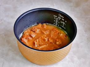 再把煸炒过的排骨倒入电饭煲中，排骨铺平。