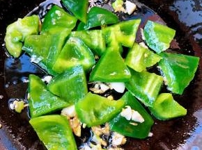 锅中倒入底油加热放入葱姜蒜爆香放入青椒炒至断生