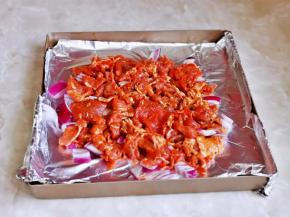 再把腌制好的牛肉片放在洋葱上，尽量把牛肉片摊开。