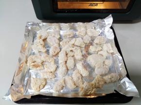 冷冻的半成品鸡米花取出，放铺了锡纸的烤盘上。