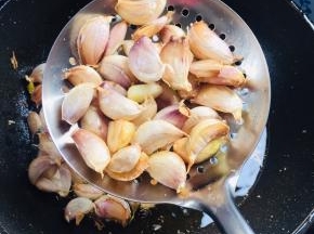 炸至蒜瓣皮开口就可以捞出沥干油份备用了！