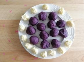 然后将芝士碎分成7克一个，戴上PVC手套（手温会让芝士碎出油，所以建议戴手套，不然手上油油的），搓成团备用！将炒好的紫薯馅料分成35克一个，搓圆备用。