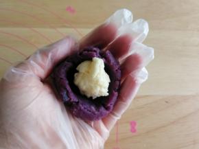 然后左手取一个紫薯馅料球，右手大拇指从中间按下去呈半圆，放入芝士球。