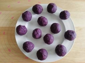 右手虎口将紫薯泥慢慢往上推，将芝士球包裹住，搓圆备用。一定要将芝士碎全部包裹住。全部操作好，盖上保鲜膜，防止风干开裂。