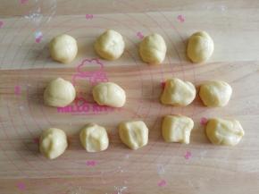 静置好的面团，撒些低粉在案板上防粘，然后搓成长条，分成28克一个，13个面团。盖上保鲜膜。