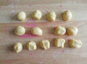 静置好的面团，撒些低粉在案板上防粘，然后搓成长条，分成28克一个，13个面团。盖上保鲜膜。