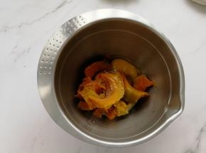 蒸熟的南瓜放入盆中，打入一个鸡蛋，加入20克牛奶。然后用刮刀按压下或者直接用蛋抽，搅打成均匀的糊。南瓜很软糯，所以操作很容易。