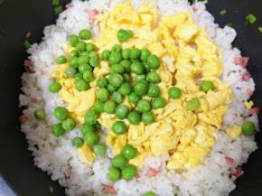 下入炒熟的鸡蛋和焯熟的豌豆。