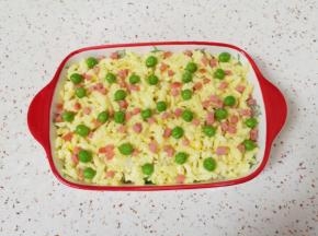 撒上一层马苏里拉芝士，上面再撒上豌豆和火腿肠。