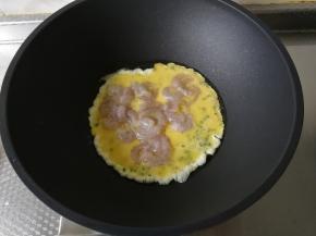 等底部的蛋液略微凝固，就可以倒入腌渍好的虾仁。