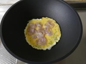 等底部的蛋液略微凝固，就可以倒入腌渍好的虾仁。