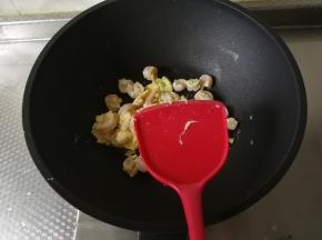然后转中火，迅速翻炒，让蛋液裹住虾仁，炒出来的蛋很嫩。速度快一些，翻炒到虾仁完全变色，变熟。淋入2勺料酒，炒匀去腥。