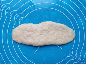 取一份面包面团用手抻开（因为面团特别软，可以不用擀面杖）。