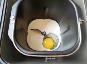 面包机桶内加入牛奶，打入一个鸡蛋。