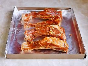 腌制好的排骨，摆放在垫好锡纸的烤盘中。（姜蒜抖掉，不然经过烘烤易糊）