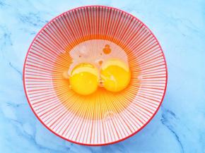 鸡蛋磕入碗中。