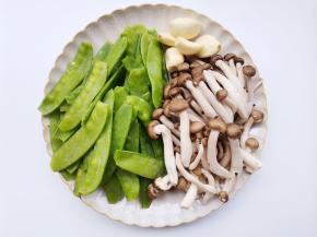 荷兰豆洗净去筋，菌菇切去根部洗净，蒜切末。