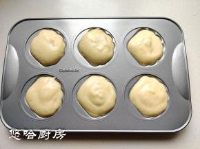 拌匀的面糊用汤匙或裱花袋挤入模具中，面糊略有剩余，装在一个小纸杯里一起烤。