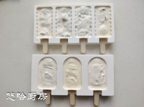 把冰糕棍从模具的下方插进去，第一次使用模具的时候最好先用剪刀把插口的地方剪开或捅开，冰糕棍容易插进去。拌匀的酸奶糊装入裱花袋，挤入模具中。建议用裱花袋或保鲜袋，方便好用，用勺子会弄到外面。弄好之后模具在台面上震几下，表面会平整一些。