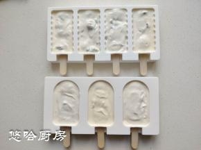 把冰糕棍从模具的下方插进去，第一次使用模具的时候最好先用剪刀把插口的地方剪开或捅开，冰糕棍容易插进去。拌匀的酸奶糊装入裱花袋，挤入模具中。建议用裱花袋或保鲜袋，方便好用，用勺子会弄到外面。弄好之后模具在台面上震几下，表面会平整一些。