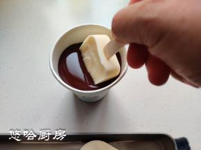 融化后的黑巧装入纸杯中，把雪糕插入纸杯中，用手捏一下纸杯，让巧克力沾满雪糕，提出雪糕，巧克力很快就凝固。