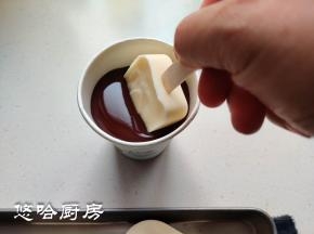 融化后的黑巧装入纸杯中，把雪糕插入纸杯中，用手捏一下纸杯，让巧克力沾满雪糕，提出雪糕，巧克力很快就凝固。