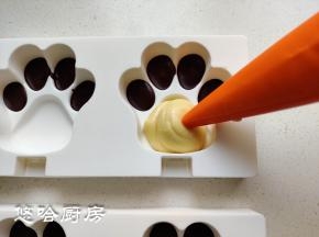 熊掌硅胶模具中，先挤入融化的黑巧克力在脚趾头的位置，放冰箱冷冻至黑巧凝固。