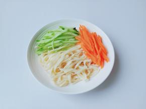 碗里码上面条、胡萝卜、豆芽、黄瓜丝。