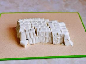 豆腐倒扣在砧板上，再切小块。