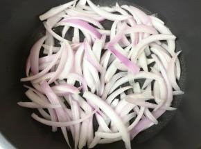 不粘锅里倒入少许食用油烧热，下入洋葱丝。