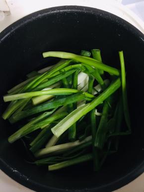 香葱切成段，铺到电饭锅底儿！