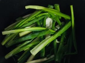 香葱切成段，铺到电饭锅底儿！