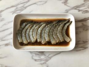 虾仁中加入一勺料酒、一勺生抽、少许盐和黑胡椒粉，抓匀后，腌制15分钟以上。
