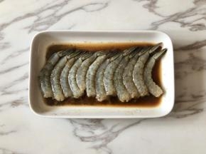 虾仁中加入一勺料酒、一勺生抽、少许盐和黑胡椒粉，抓匀后，腌制15分钟以上。