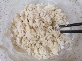 将酵母水倒入面粉中，一边倒一边用筷子搅拌成絮状。