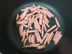 不粘锅继续倒油烧热，下入香肠条。